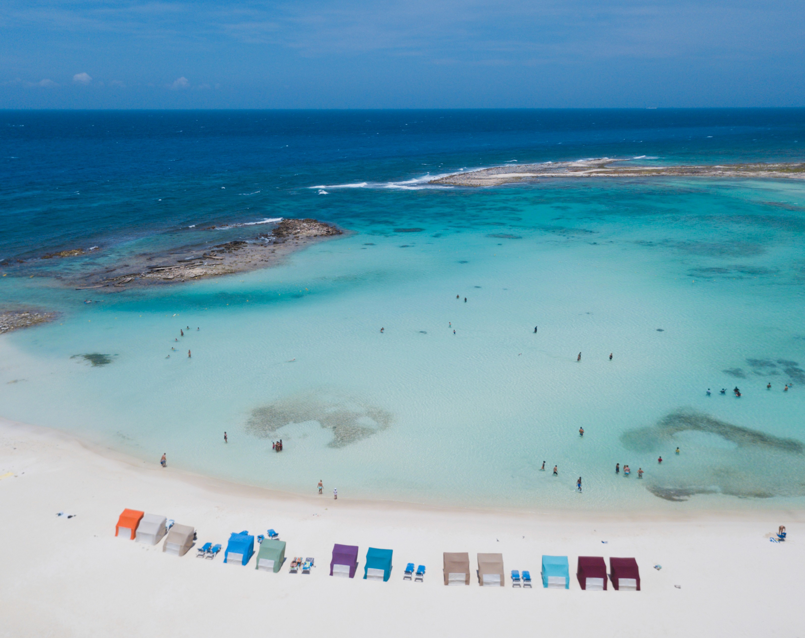 Aerial view of Aruba's turquoise water and beach cabanas.